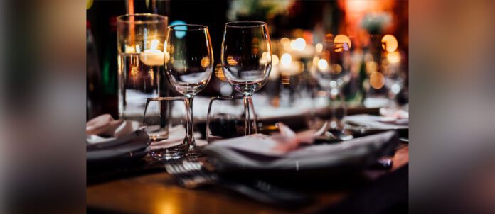 Luxury table settings for fine dining with and glassware, pouring wine to glass.