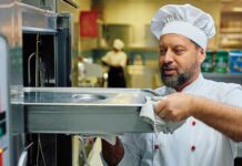 Chef taking food out of industrial oven