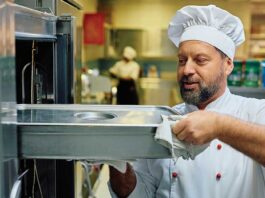 Chef taking food out of industrial oven