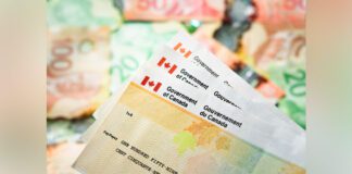 Stack of Canadian tax refund cheques with Canadian currency in the background