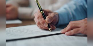 Closeup of CEO hands signing contract in office