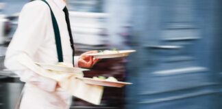 Waiter holding two plates of food