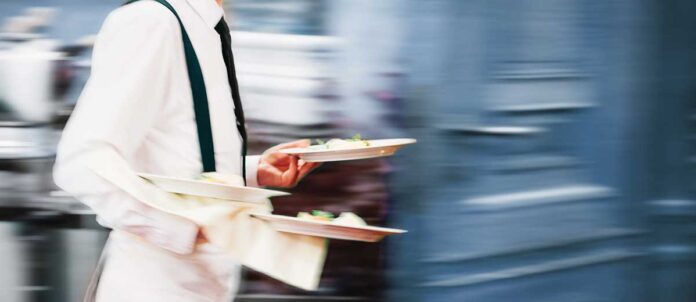 Waiter holding two plates of food