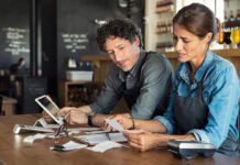 Man and woman sitting in restaurant discussing finance for the month