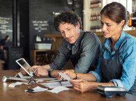 Man and woman sitting in restaurant discussing finance for the month