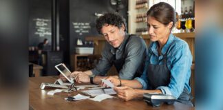 Man and woman sitting in restaurant discussing finance for the month