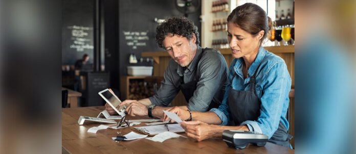 Man and woman sitting in restaurant discussing finance for the month