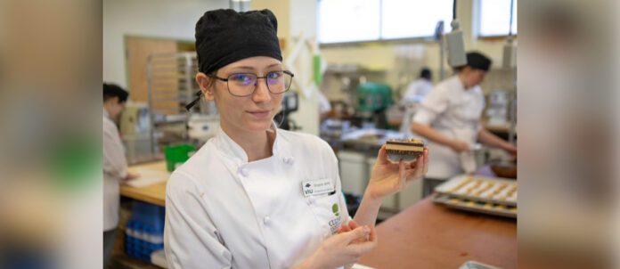 VIU Baking and Pastry Arts Management Diploma Program student Shayla Jane Heslin holds up a Nanaimo bar