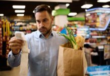 man checking the bill after buying groceries at supermarket